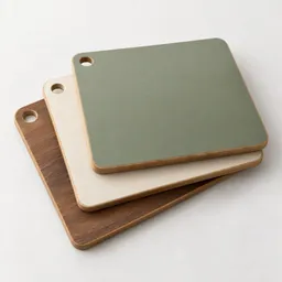 A centered stack of three plain rectangular cutting boards on a light neutral background.