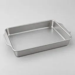 Centered rectangular metal baking pan with low sides and integrated handles on a neutral light background.