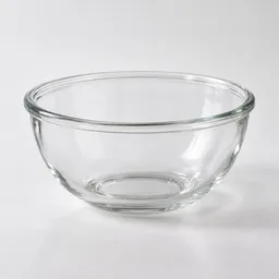 Centered studio photograph of a clear heatproof glass bowl on a neutral light background.