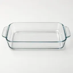 Centered transparent rectangular 9x13-inch glass baking dish with rounded corners and integrated side handles on a light neutral background.