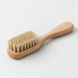Centered unbranded vegetable brush with a light wooden handle and dense natural bristles on a neutral light background.