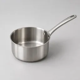 Centered stainless-steel saucepan with a long handle on a neutral light-gray studio background.