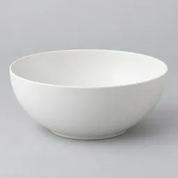 Large white ceramic salad bowl centered on a light neutral studio background.
