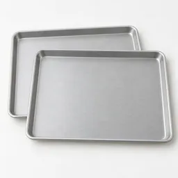 Two unbranded silver 13-by-18-inch rimmed baking sheets arranged as an overlapping pair on a neutral light background.