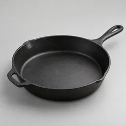 Centered studio photograph of a black 12-inch heavy cast-iron skillet with a long handle and opposite helper handle on a neutral light background.