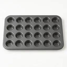 Centered mini muffin tin with multiple small round cups on a plain light background.