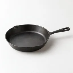 Centered medium dark metal skillet on a neutral light background.