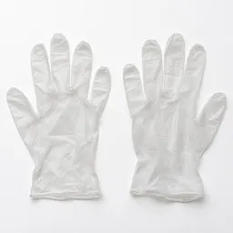 Centered studio photograph of a pair of translucent white disposable food-safe gloves on a neutral light background.