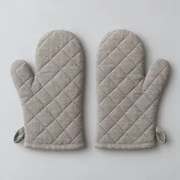 A centered pair of quilted gray oven mitts on a light neutral background.