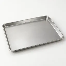 Centered studio photograph of a plain silver 13-by-18-inch rimmed metal baking tray on a light neutral background.