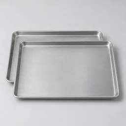 Two unbranded rectangular aluminum baking sheets centered on a light neutral background.