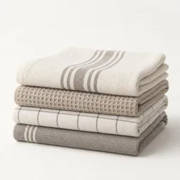 Neatly folded stack of clean kitchen towels photographed against a plain light background.