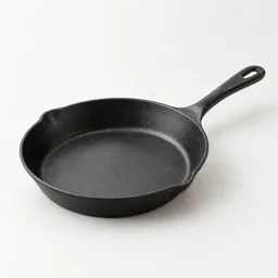 Centered studio photograph of a single dark metal skillet on a neutral light background.