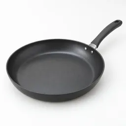 Large dark nonstick skillet photographed alone, centered on a neutral light background.